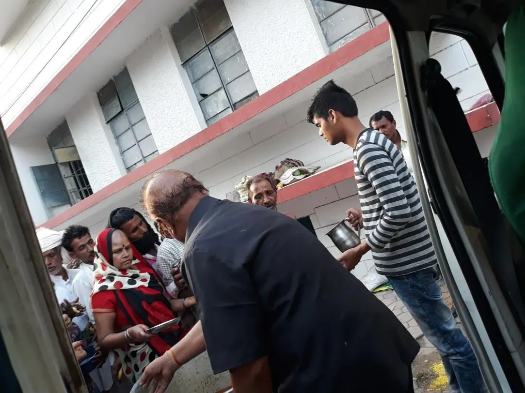 Serving meals from a distribution van at a hospital gate in Indore