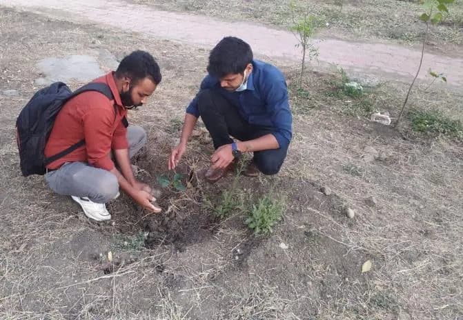 Planting a sapling with volunteers.