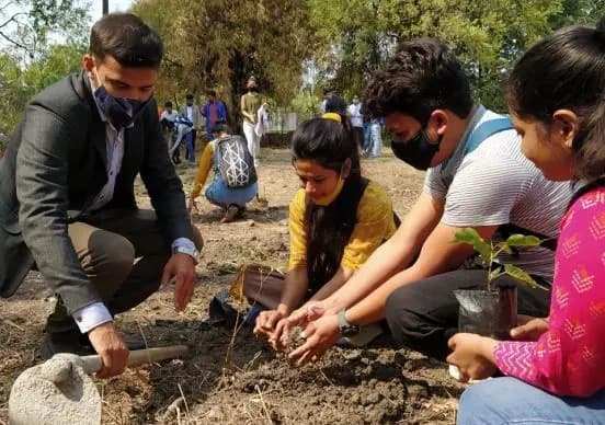 Volunteers planting saplings together.