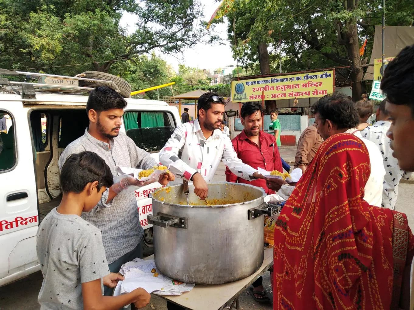 Families queue for free meals outside a government hospital in Indore